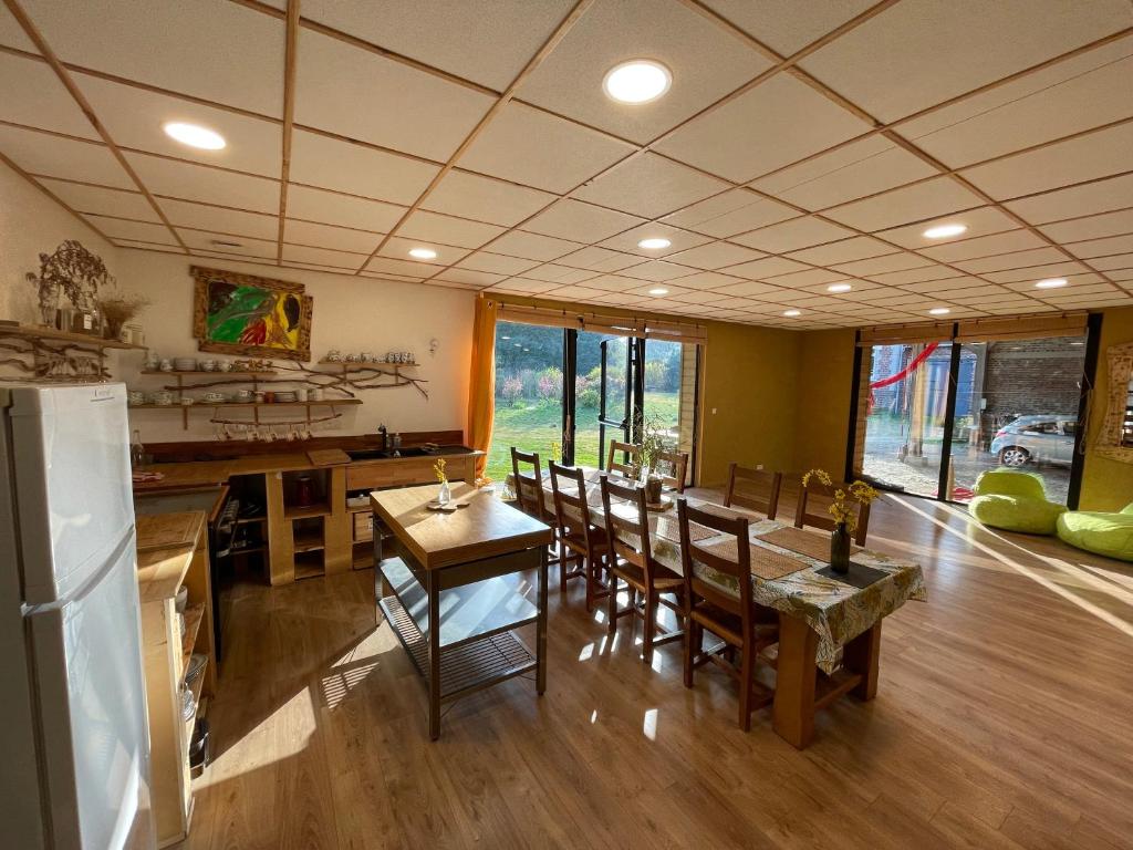 una cucina e una sala da pranzo con tavolo e sedie di Holiday home on farm (La Ferme du Tao) a Beaugies-sous-Bois