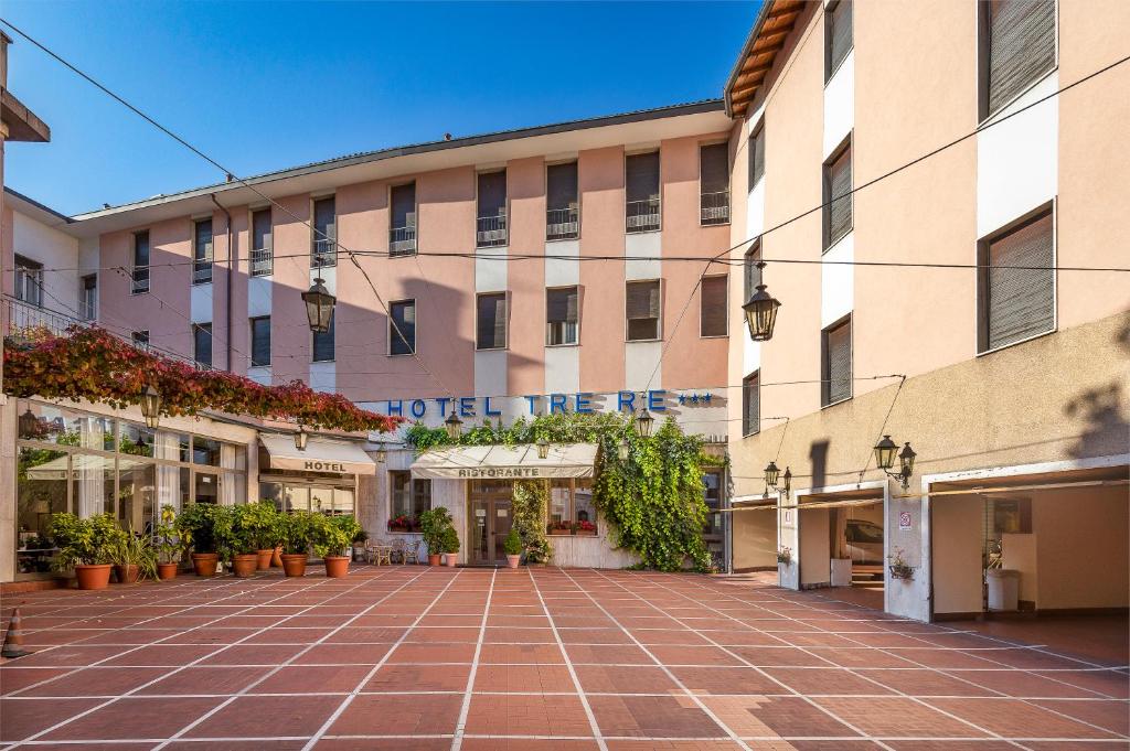 un gran edificio con un patio de ladrillo rojo en Hotel Tre Re, en Como