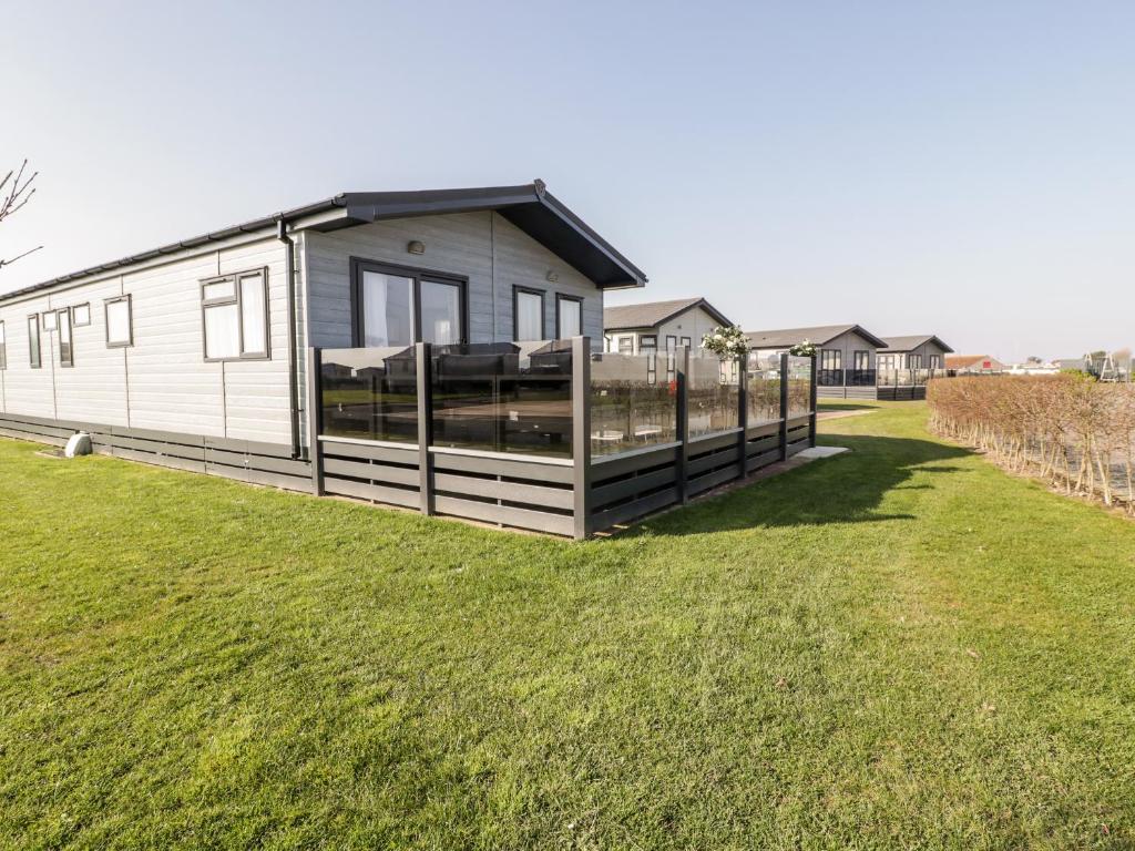 een modulair huis met een hek in een tuin bij Fairways 4 - Sunny Meadows in Burnham on Sea