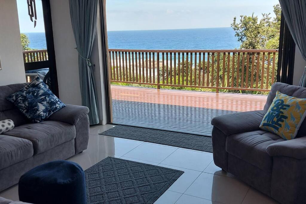 a living room with two couches and a view of the ocean at On The Beach @ South Sands.No 2 in Port Edward