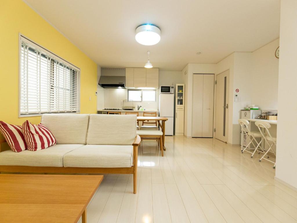a living room with a white couch and a kitchen at Kinugawa Station Front room B in Nikko