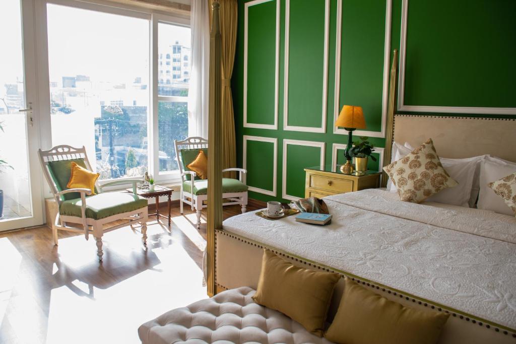 a bedroom with a large bed and a green wall at Dileep Kothi - A Royal Boutique Luxury Suites in Jaipur in Jaipur