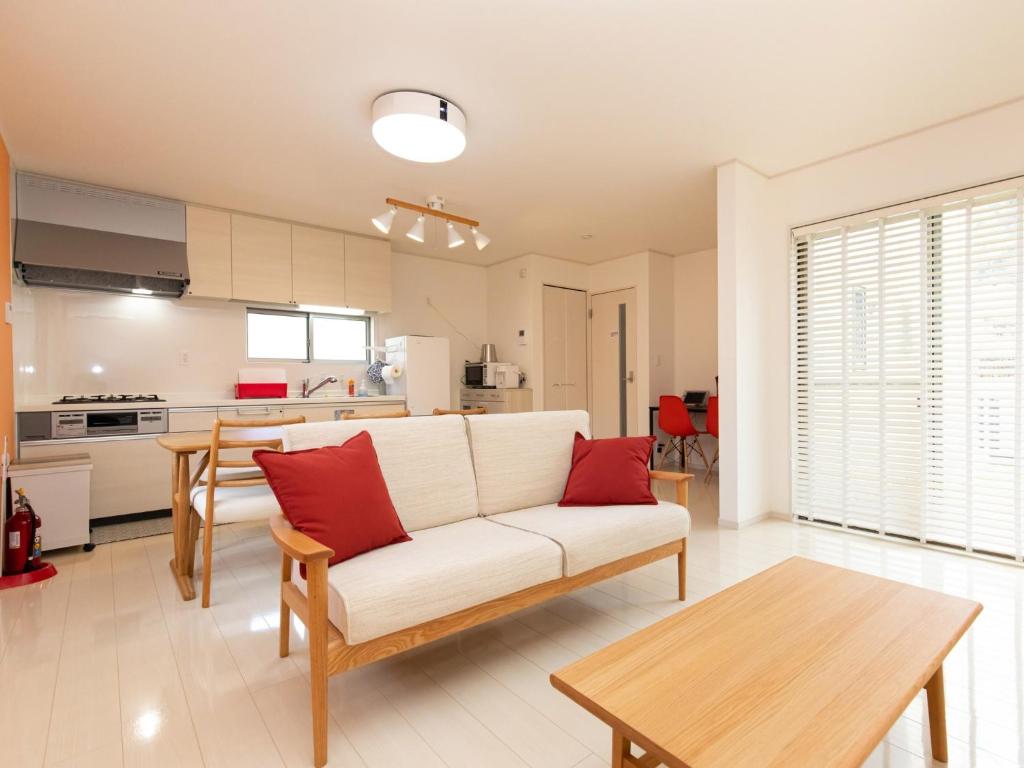 uma sala de estar com um sofá branco e almofadas vermelhas em Kinugawa Station Front room D em Nikko