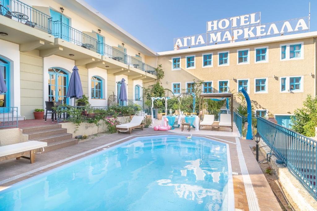 um hotel com piscina em frente a um edifício em Agia Markella em Vrontádos