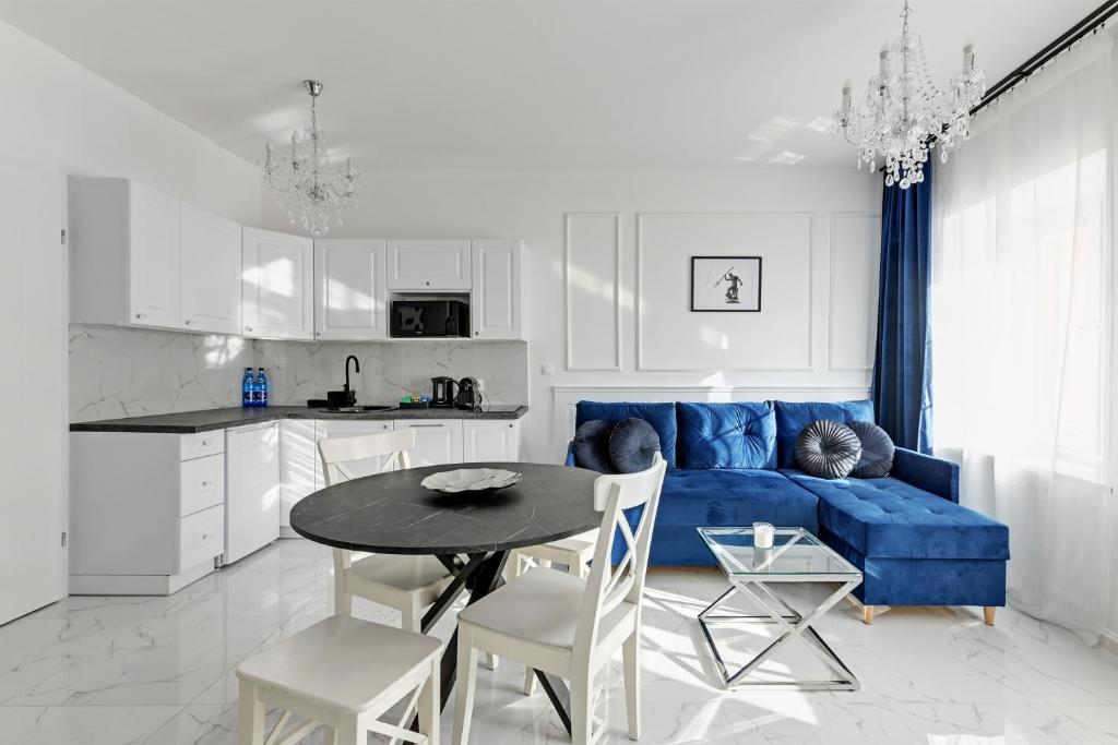 uma sala de estar com um sofá azul e uma mesa em Downtown Apartments Old Town Długa em Gdańsk