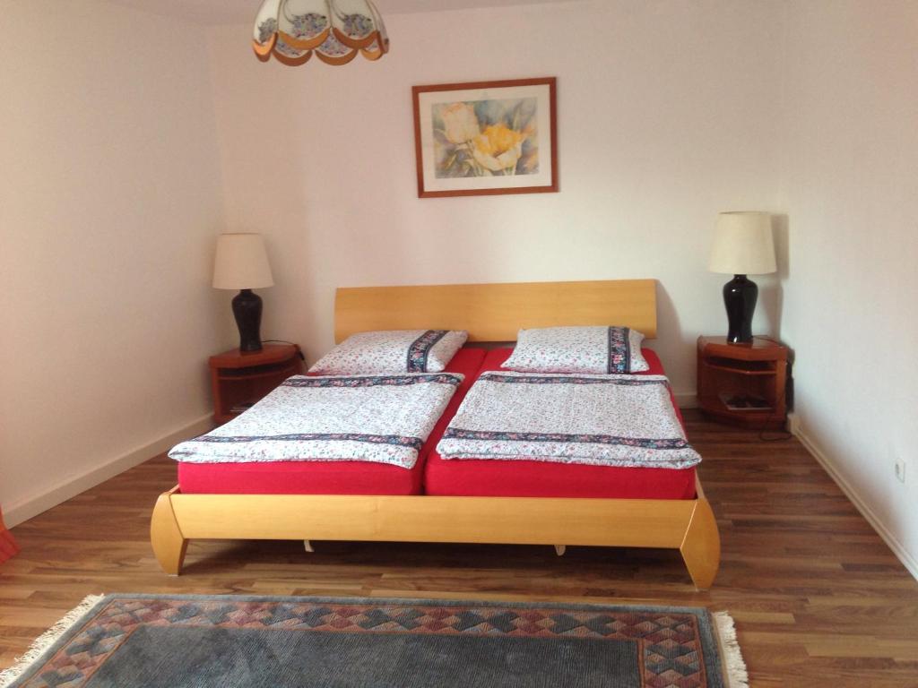 ein Schlafzimmer mit einem Bett und zwei Nachttischen in der Unterkunft Apartment Nürnberg-City in Nürnberg