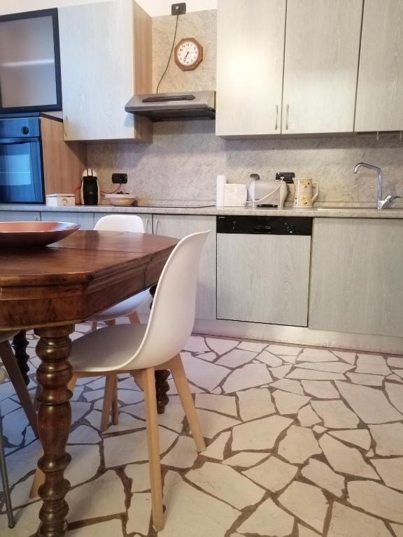 kuchnia z drewnianym stołem i białymi szafkami w obiekcie B&B Sotto le Mura w Bergamo