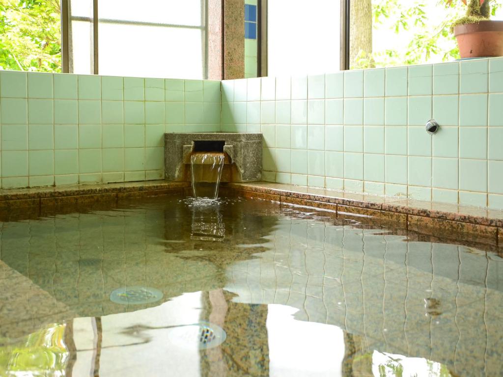 - une piscine d'eau dans la salle de bains pourvue d'une fontaine dans l'établissement Maruyaso, à Fujikawaguchiko