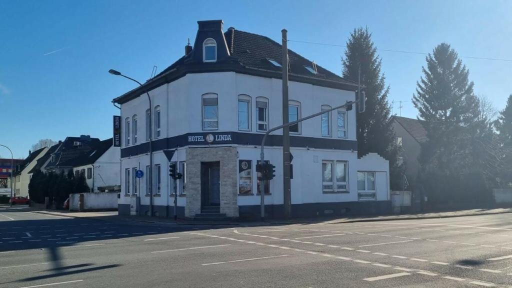 a white building on the corner of a street at Hotel Linda in Gladbeck