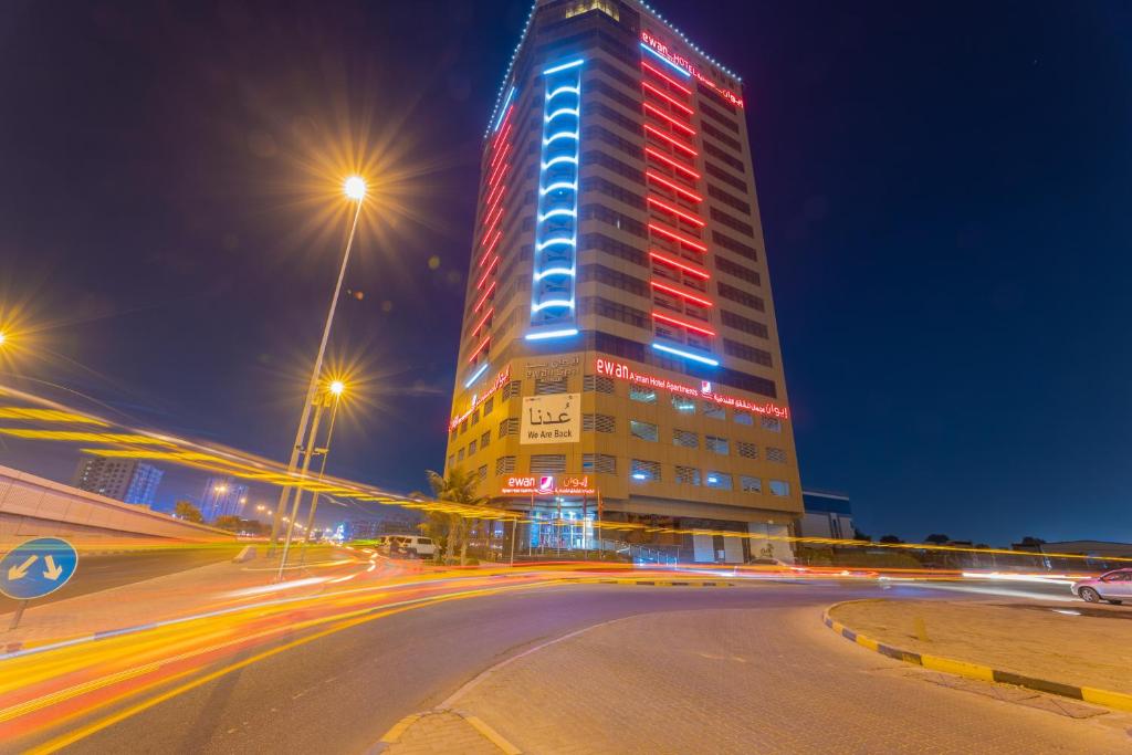 a tall building with red and blue lights on it at Ewan Ajman Suites Hotel in Ajman 