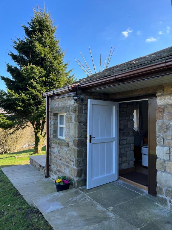 a stone building with a white door next to it at Stunning location on Pendle Hill in Nelson
