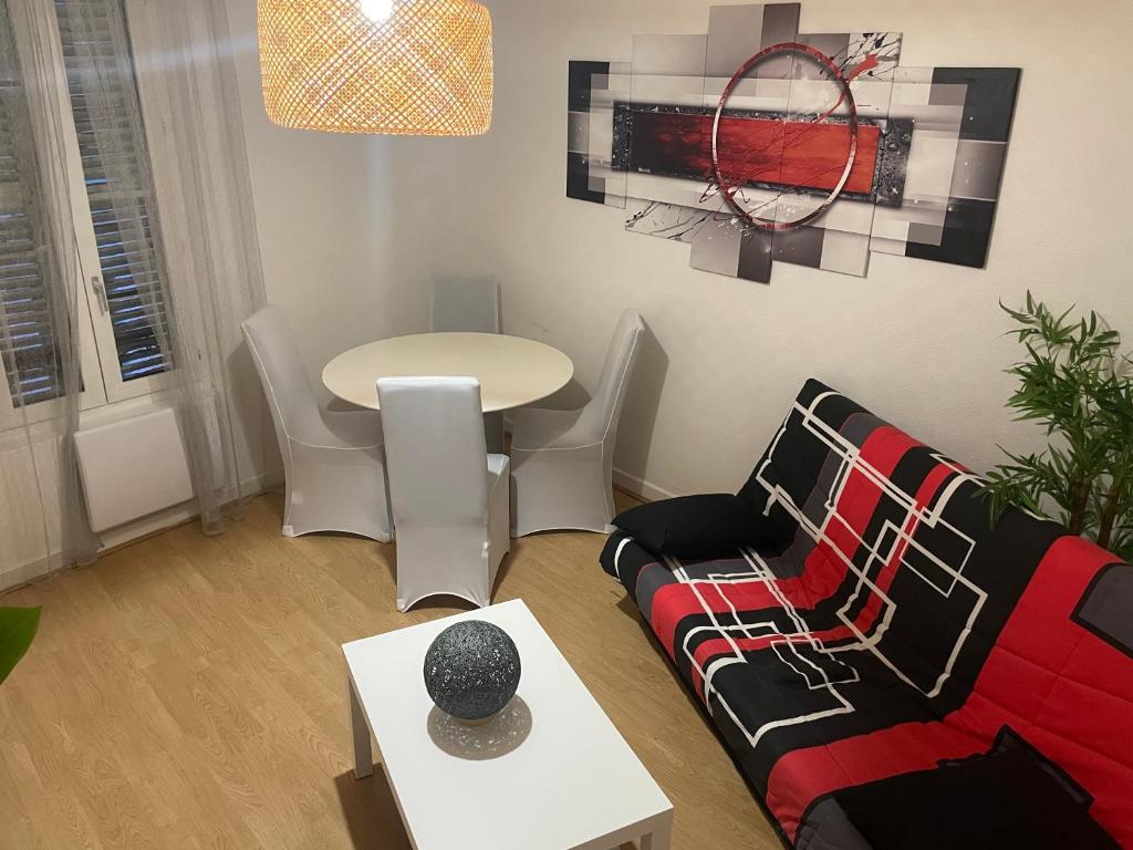 a living room with a couch and a table at Appartement complet hyper centre in Auxerre