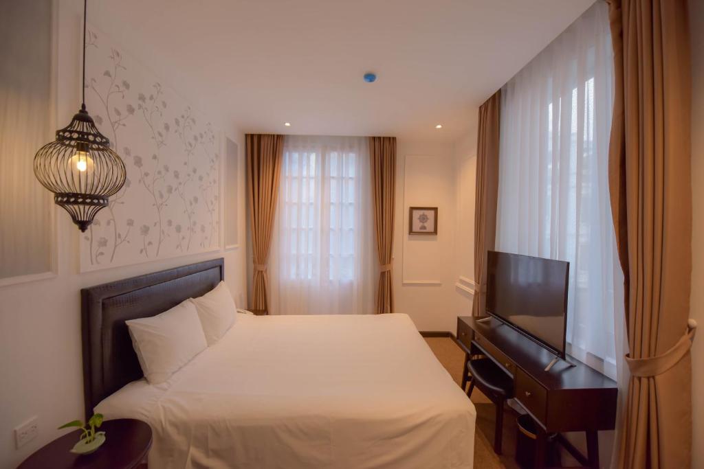 a bedroom with a bed and a flat screen tv at Rosa Hanoi Hotel in Hanoi