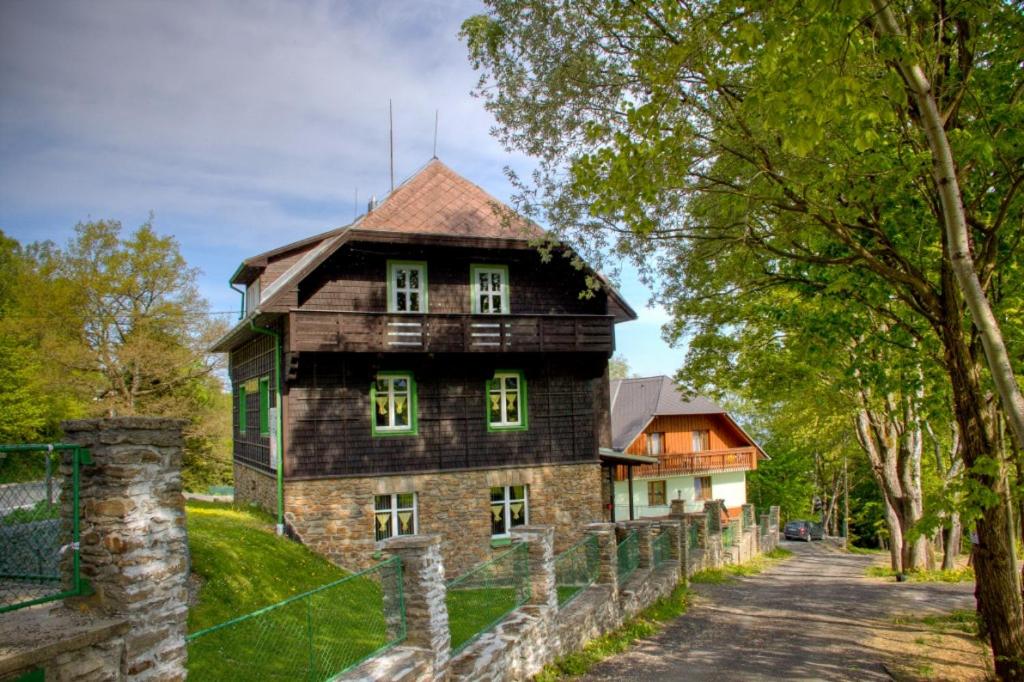 uma casa velha com uma cerca em frente em Chata Šumava em Hojsova Stráz