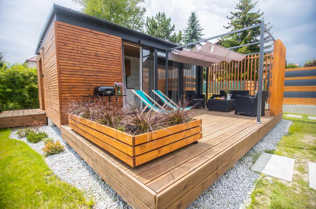 una casa con una terraza de madera con sillas en Legowisko bed & sauna Szczyrk en Szczyrk