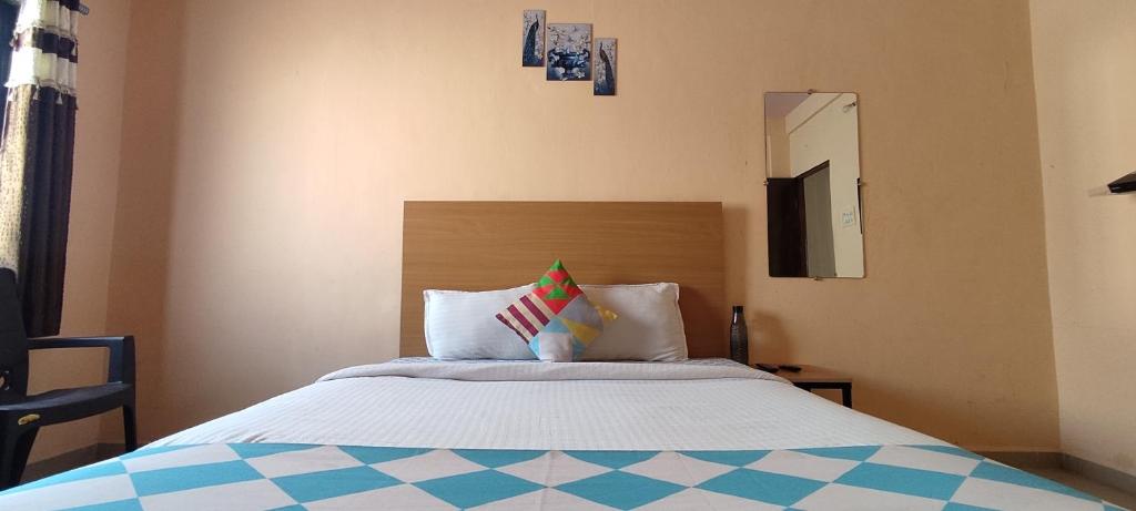 a bedroom with a large bed with white sheets and a mirror at AMBIENT HOME STAY, In Nashik in Nashik