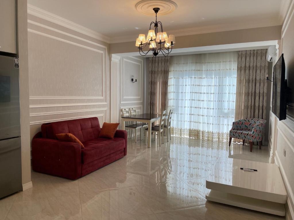 uma sala de estar com um sofá vermelho e uma mesa em Azzure VIP em Baku