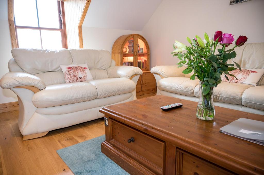 a living room with two couches and a vase of flowers at Fort Charlotte in Lerwick