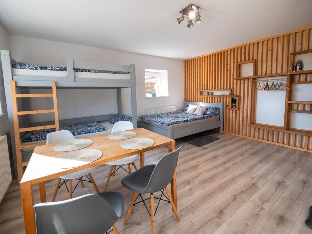 een kamer met een tafel en stoelen en een stapelbed bij Kwatera Karkonoska in Jelenia Góra