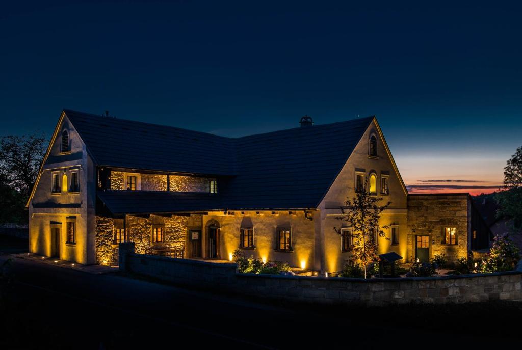una gran casa de piedra por la noche con luces en RESORT KOVÁRNA - Frýdštejn - stylové ubytování, luxusní wellness, zážitková restaurace en Hodkovice nad Mohelkou
