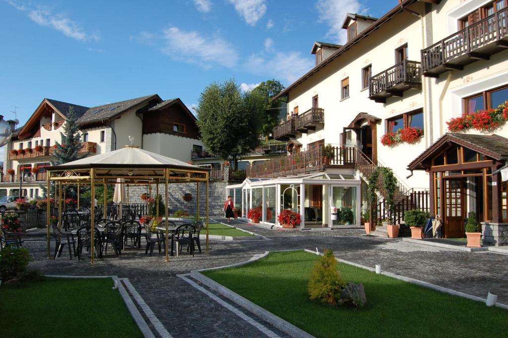 een hotel met tafels en stoelen op een binnenplaats bij Albergo Edelweiss - LareSpa in Crodo