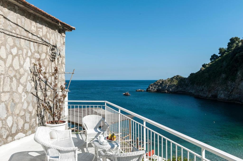 a balcony with chairs and a view of the ocean at La Conca del Sogno in Massa Lubrense