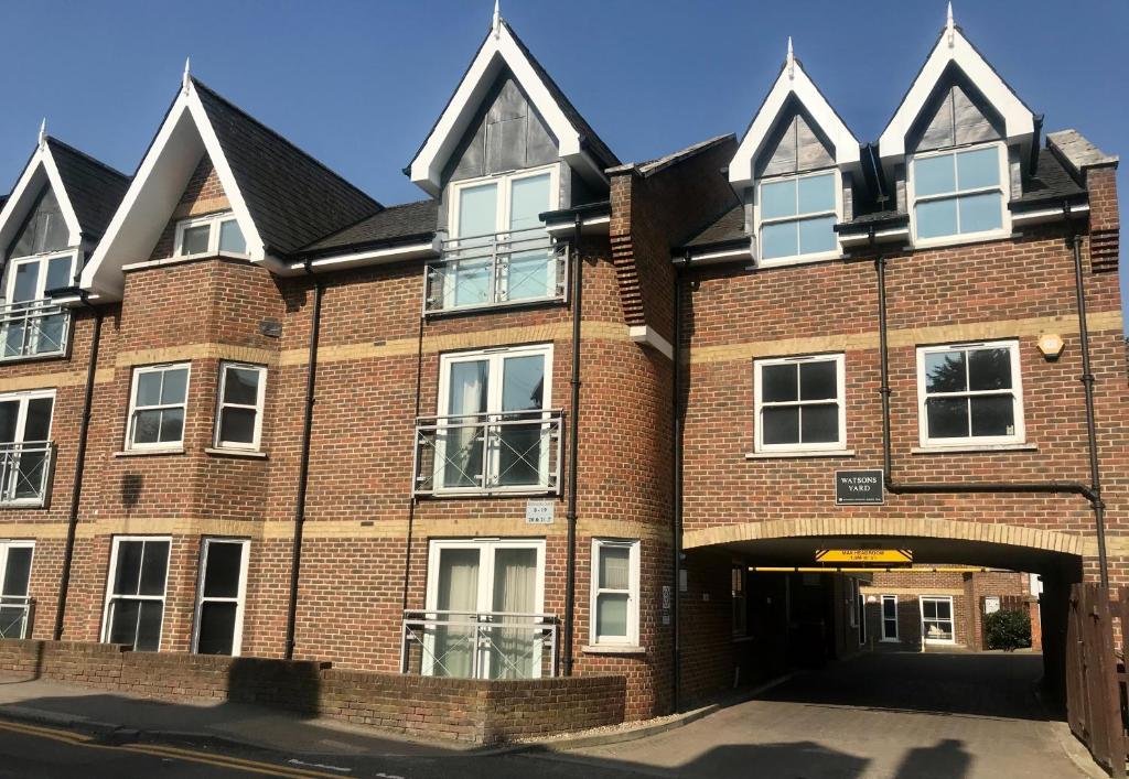 a large red brick building with a garage at Central 2 Bed, 2 Bathrooms, Ground Floor Apartment with Parking in Bishops Stortford