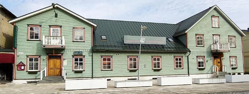 ein großes grünes Gebäude mit schwarzem Dach in der Unterkunft Katariina Guesthouse in Rakvere
