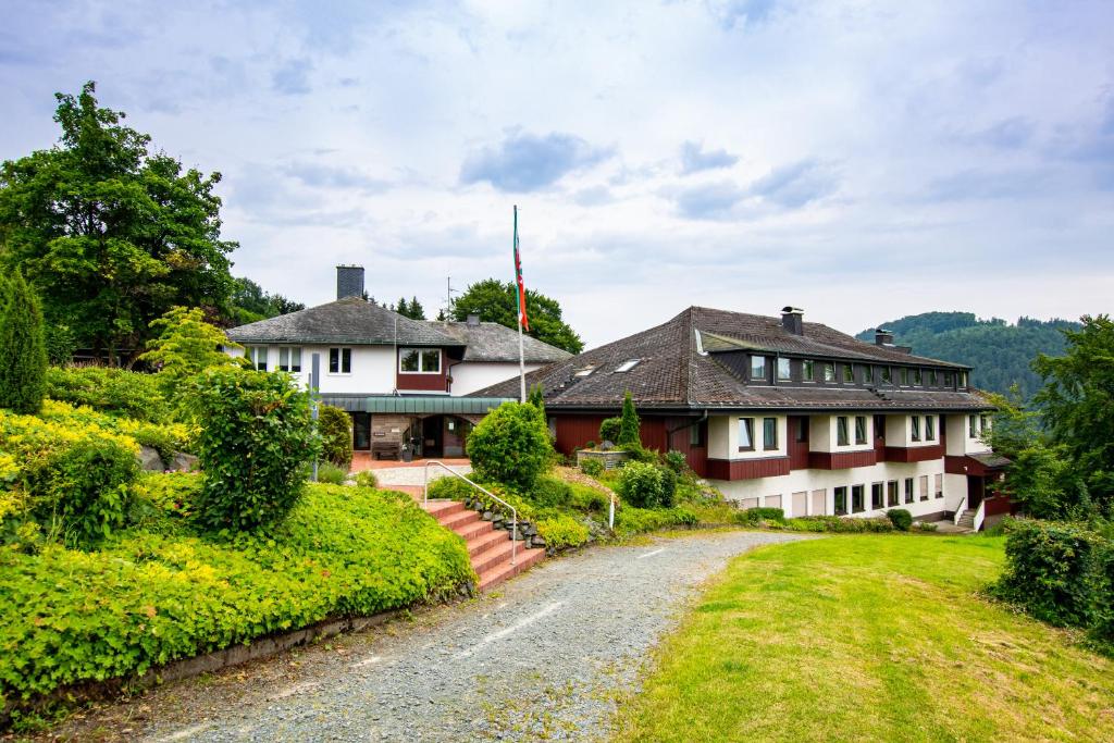 a house on a hill with a driveway at Panorama Hotel Winterberg in Winterberg
