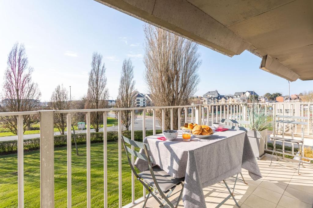 a table with a bowl of fruit on a balcony at Le P'tit Idéal in Cabourg