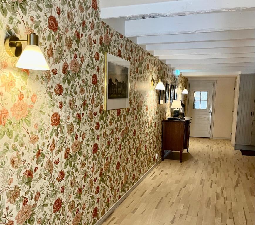 Habitación con papel floral en la pared y pasillo en Rekasta Bed & Breakfast, en Enköping