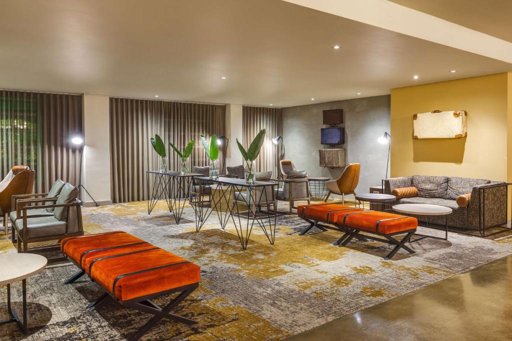 a lobby with chairs and tables and a couch at Garden Court Victoria Junction in Cape Town