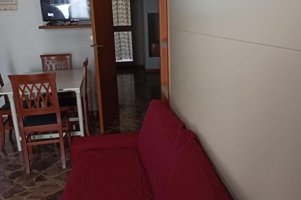 ein Wohnzimmer mit einem roten Sofa und einem Tisch in der Unterkunft La Casa di Nonna Marianna in Polignano a Mare