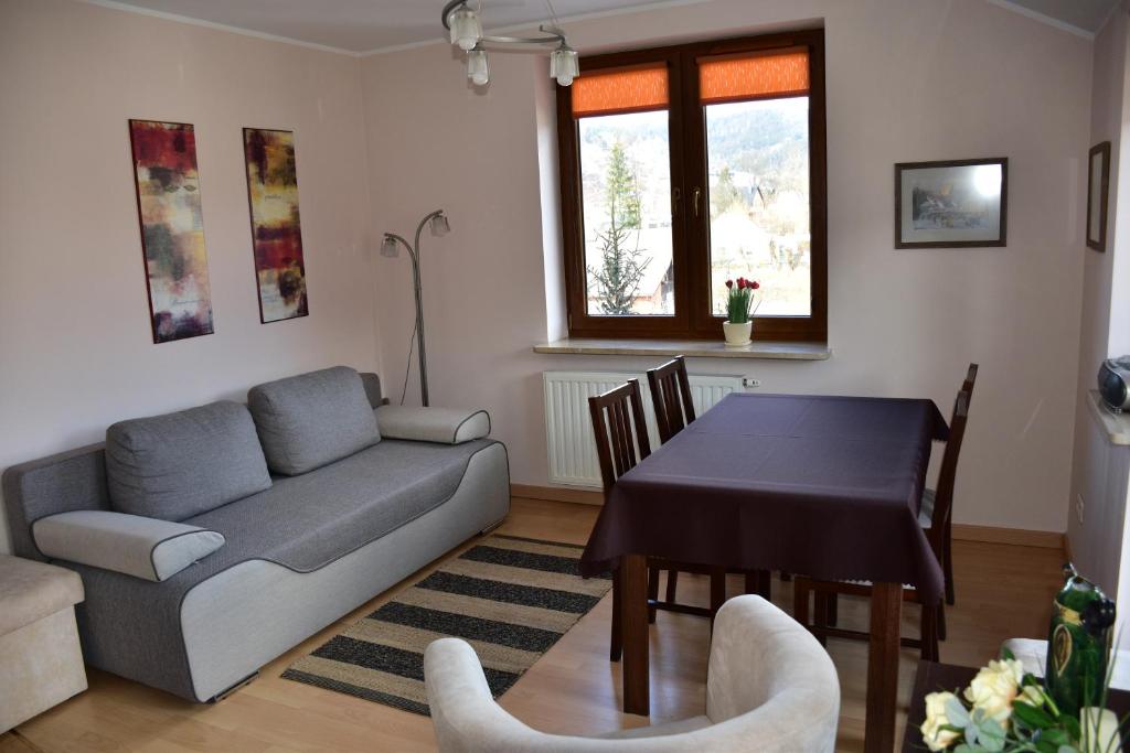 salon z kanapą i stołem w obiekcie Apartament Sonata w mieście Krynica Zdrój