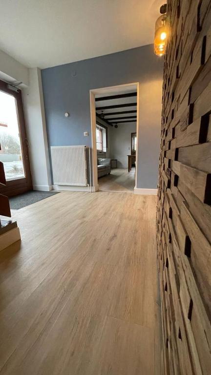 un soggiorno con pavimento in legno e muro di mattoni di Gästehaus Ivonne a Lohe-Rickelshof