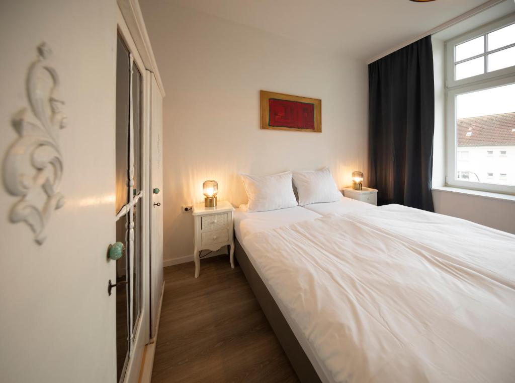 ein Schlafzimmer mit einem großen weißen Bett und einem Fenster in der Unterkunft JayBnB - Apartment direkt am Hafen mit Terrasse und UHD TV in Dortmund