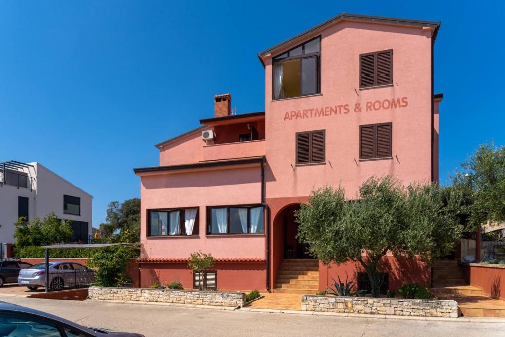 a pink building with the words apartments and rooms at Apartments Miri Vrsar in Vrsar