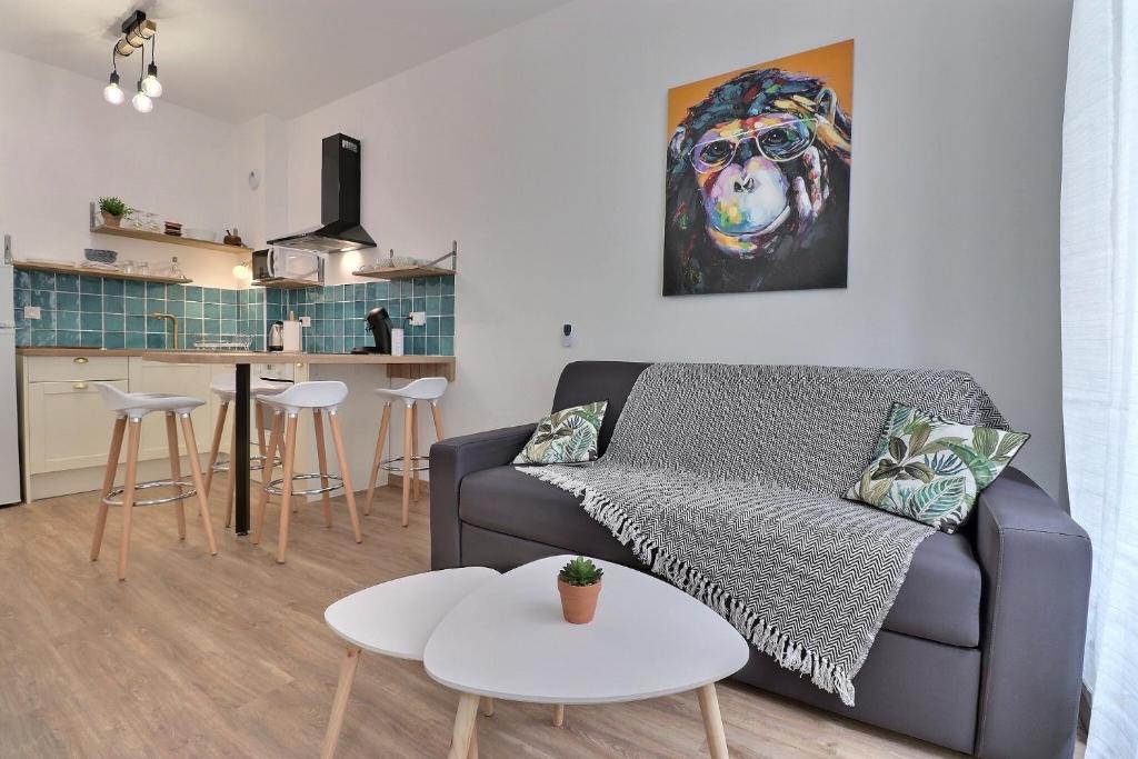a living room with a couch and a painting of a dog at Superbe appartement in Marseille