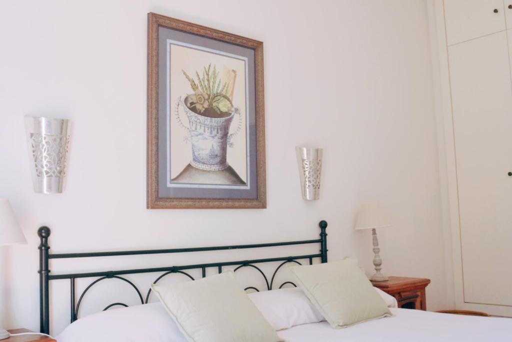 a picture of a vase on a wall above a bed at Hotel Madreselva - Grupo Califa in Los Caños de Meca