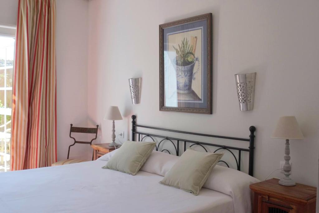 a bedroom with a bed with a picture on the wall at Hotel Madreselva - Grupo Califa in Los Caños de Meca