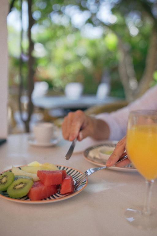 a person sitting at a table with a plate of fruit at Hotel Madreselva - Grupo Califa in Los Caños de Meca