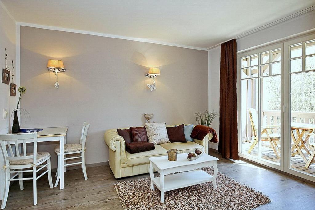 ein Wohnzimmer mit einem Sofa und einem Tisch in der Unterkunft Ostseewelle Wohnung 18 in Kühlungsborn