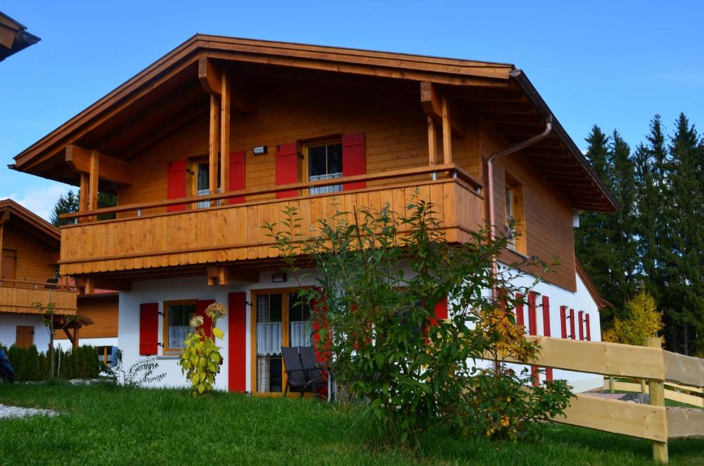 een groot huis met een rood en wit bij Feriendorf Via Claudia Haus 58 Alpenliebe in Lechbruck