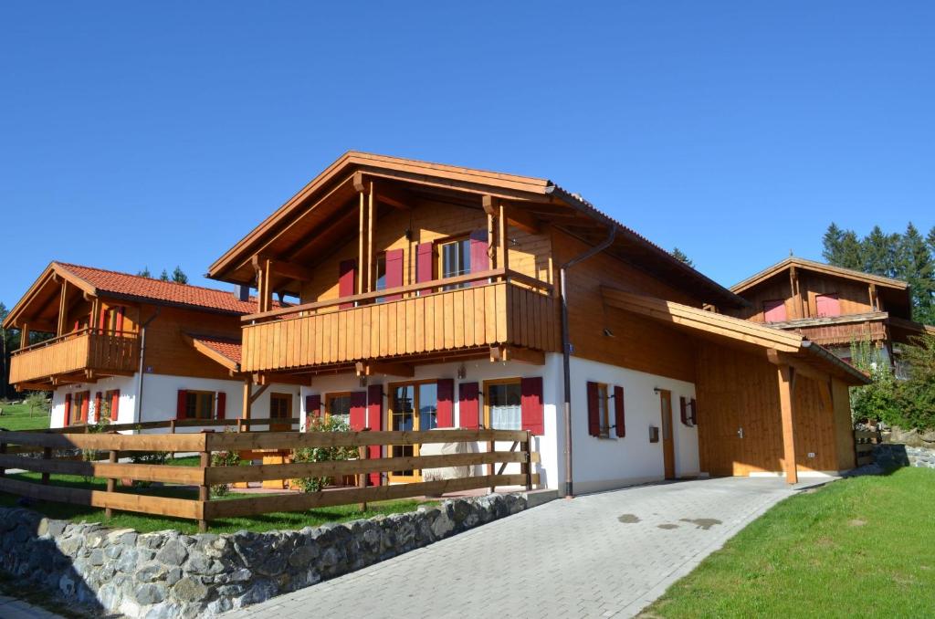 a large wooden house with a balcony at Feriendorf Via Claudia Haus 82 Alpensee in Lechbruck