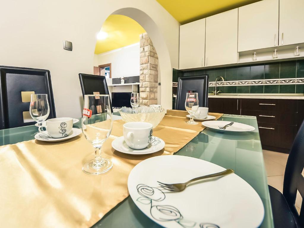 una cucina con tavolo, piatti e bicchieri di Apartment Anić-2 by Interhome a Anić