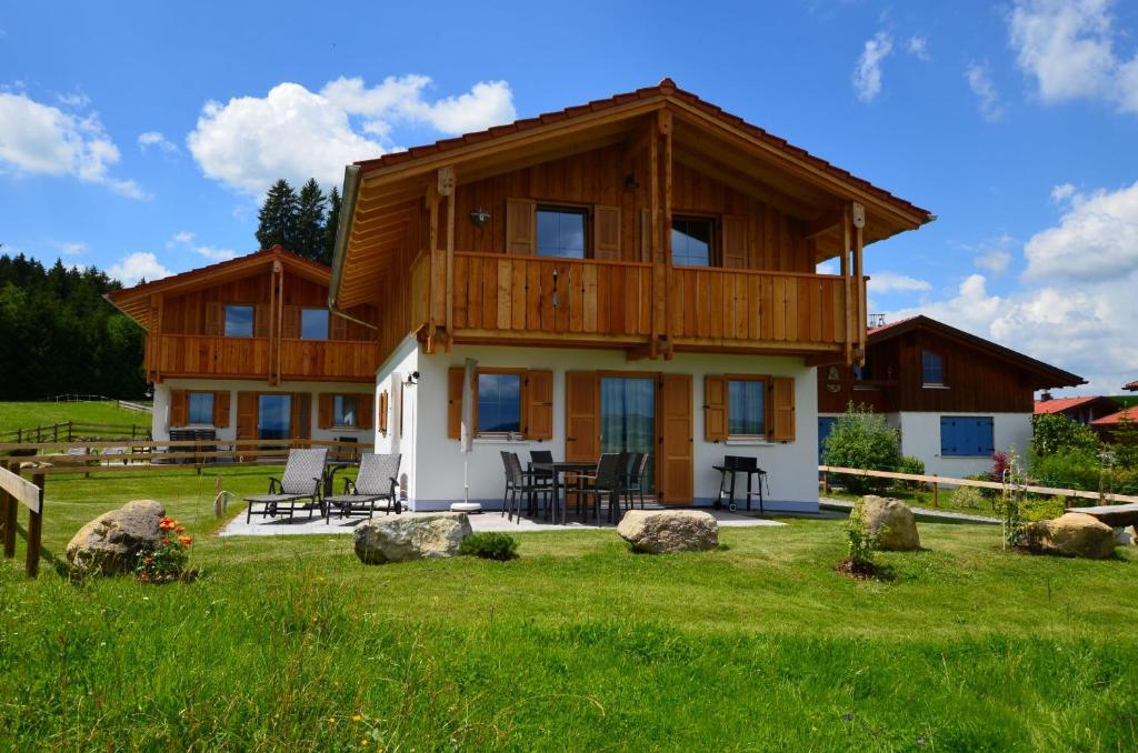 a large wooden house in a field of grass at Feriendorf Via Claudia Haus 74 Allgäuglück in Lechbruck