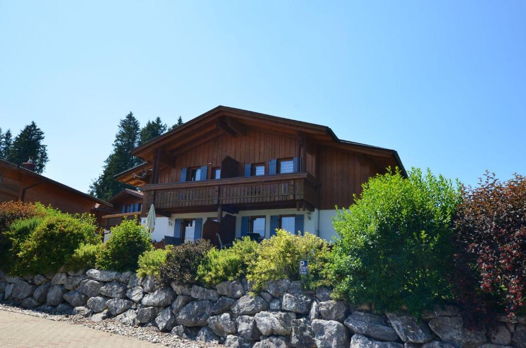 una casa con una valla de piedra delante de ella en Feriendorf Via Claudia Haus 99 Julia, en Lechbruck