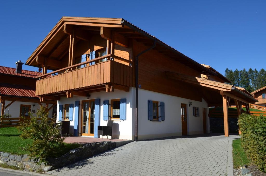 a house with a wooden roof and a balcony at Feriendorf Via Claudia Haus 62 Bernhard in Lechbruck