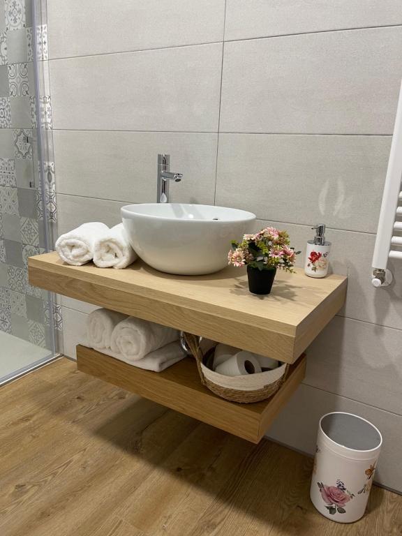 a bathroom with a sink and towels on a shelf at Estrada Suites in Avila