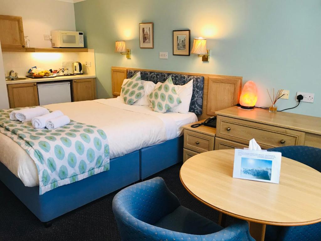 um quarto de hotel com uma cama, uma mesa e cadeiras em Marlborough House - Guest House em Oxford